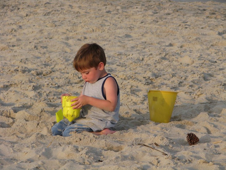 Optimized-young-boy-building-a-sand-castle-at-the-beach